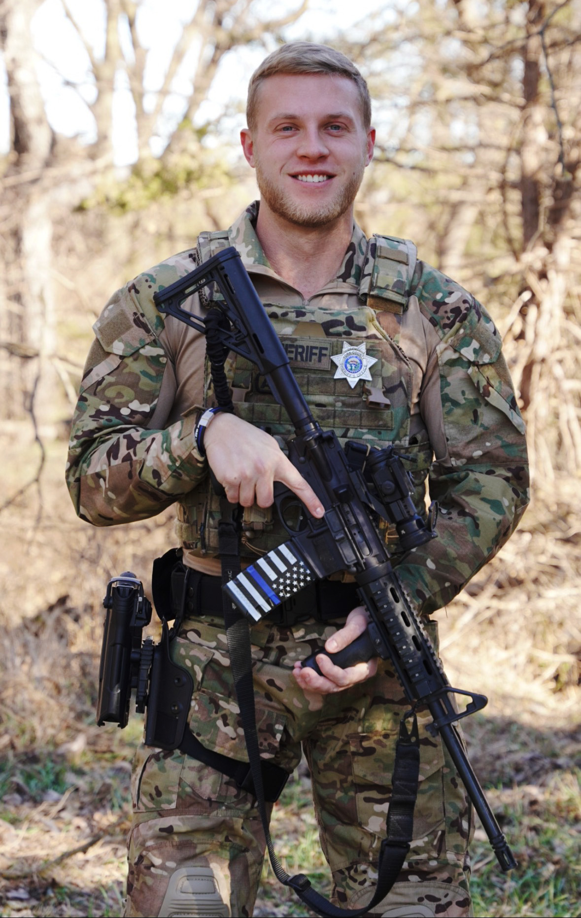 A police officer is standing in front of a building wearing a hat.