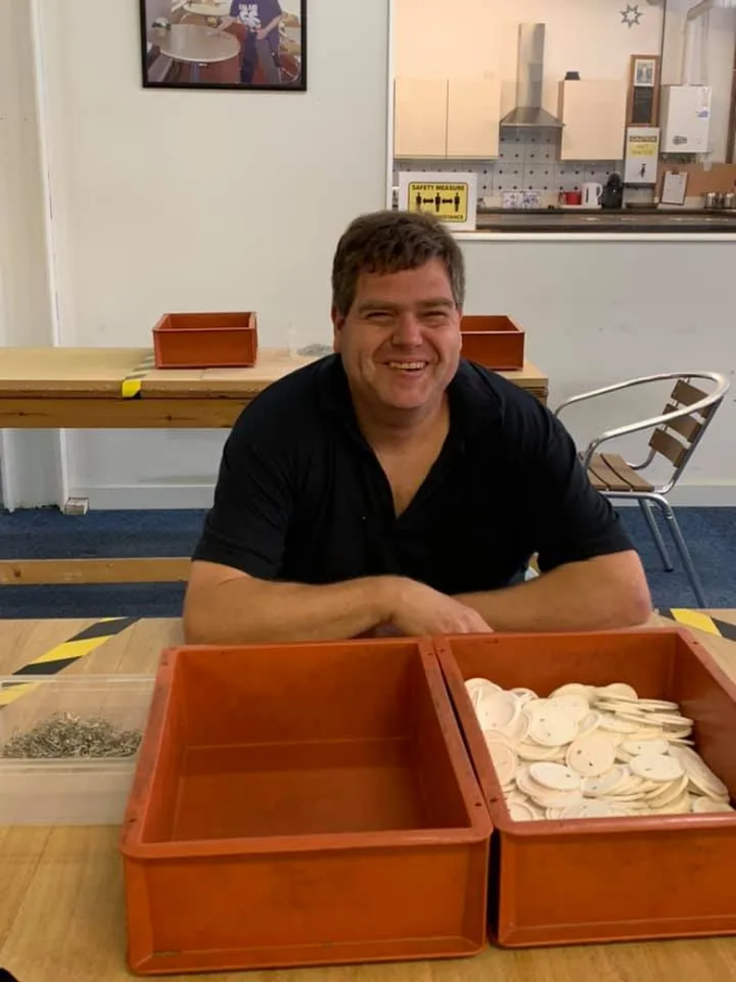 Seated man in black shirt posing for photograph