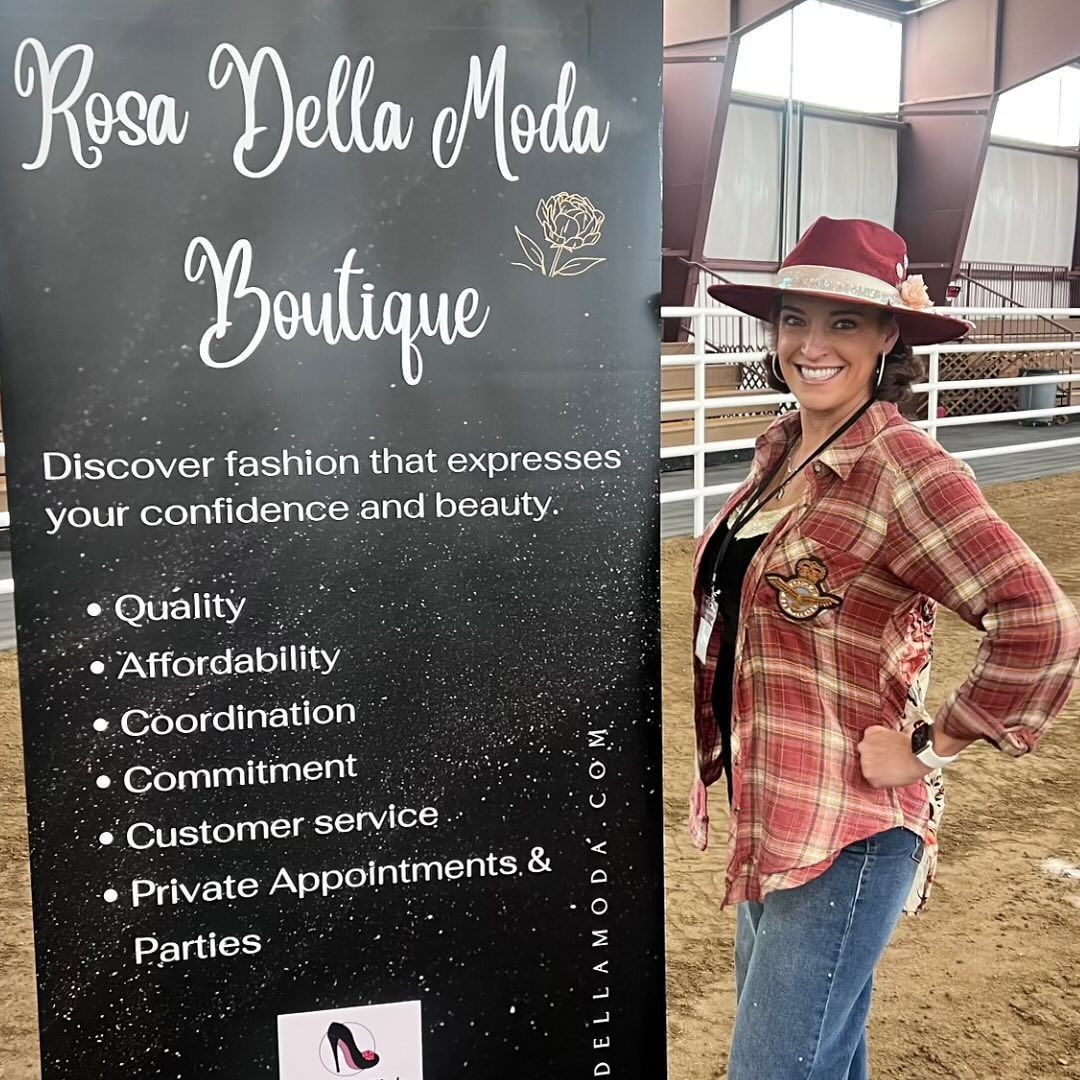 A woman is standing in front of a sign that says rosa della moda boutique