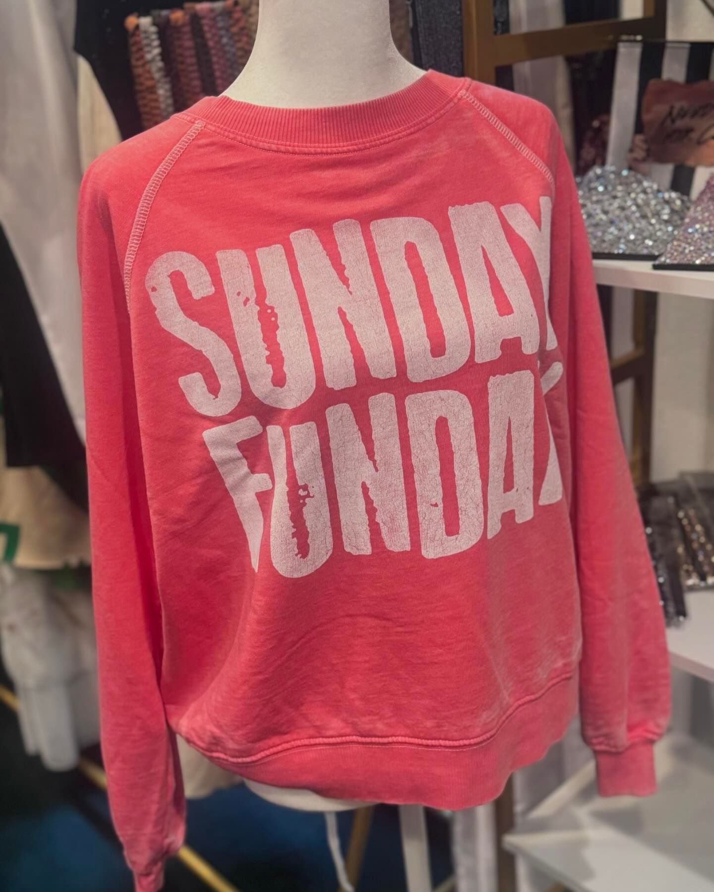 A pink sunday funday sweatshirt is on a mannequin.