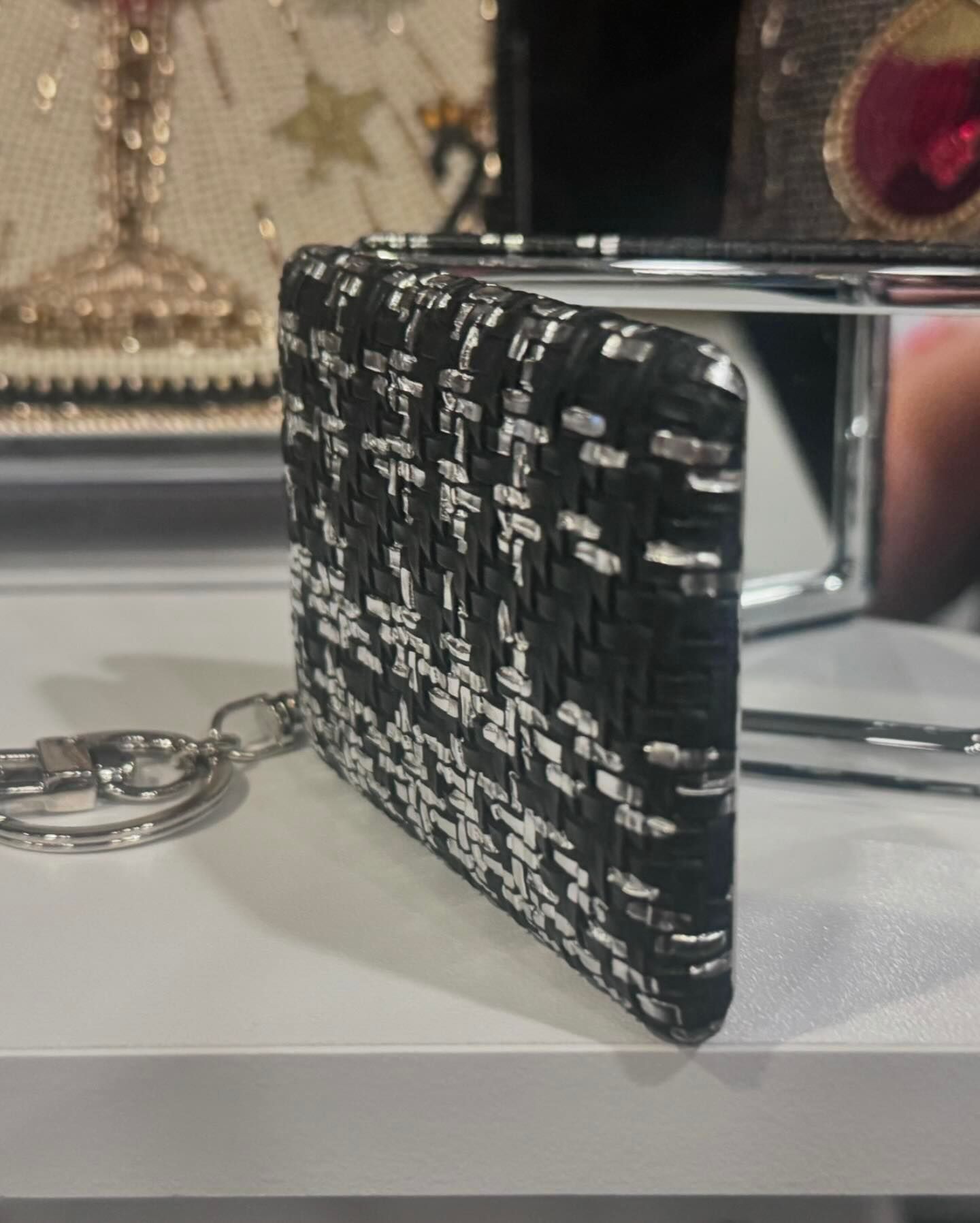 A black and white purse with a keychain attached to it