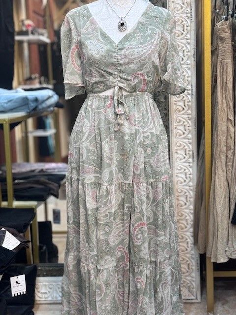 A mannequin is wearing a paisley dress in a store.