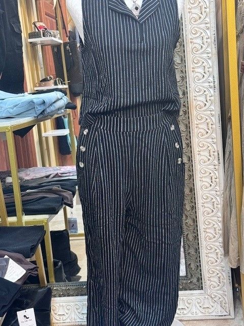 A mannequin is wearing a black and white striped vest and pants.