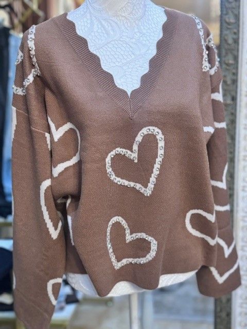 A brown sweater with white hearts on it