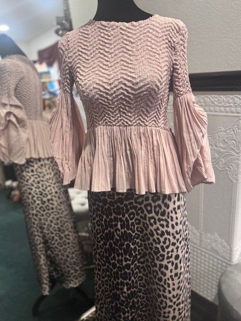 A mannequin wearing a pink top and leopard print skirt