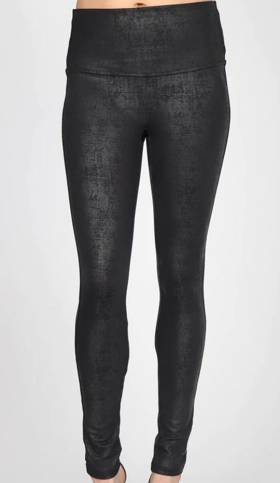 A woman is wearing a pair of black leggings with a high waist.