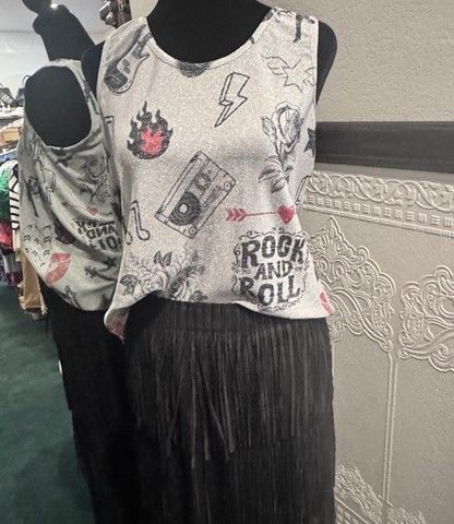 A rock and roll tank top is on a mannequin in a store.