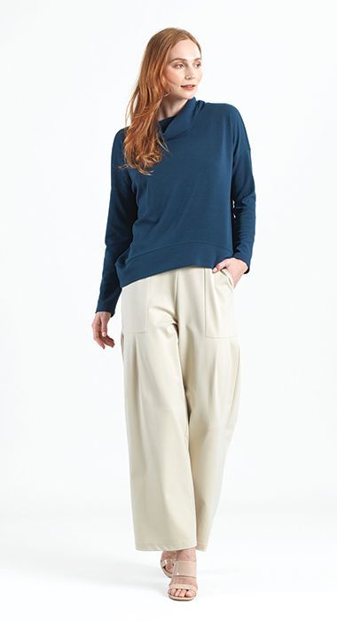 A woman is wearing a blue sweater and beige pants.