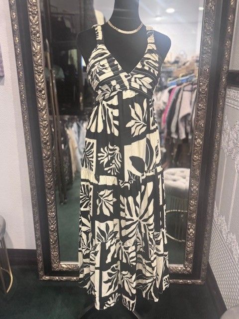 A black and white dress is on a mannequin in front of a mirror