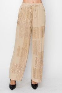 A woman is wearing a pair of wide leg pants with sequins on them.