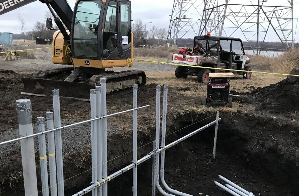 A john deere excavator is digging a hole in the ground
