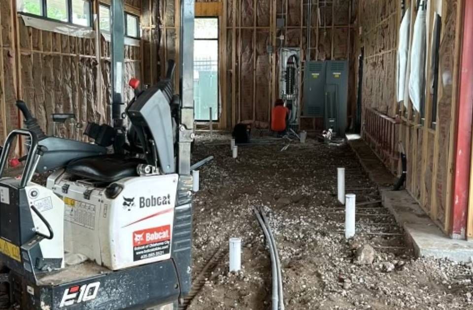 A bobcat e10 mini excavator is parked in a building under construction.