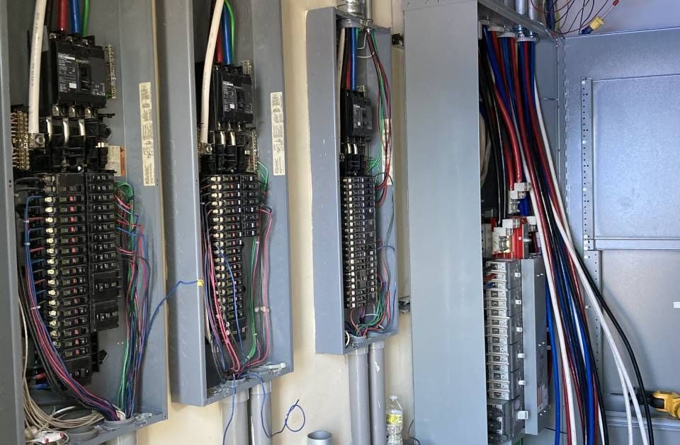 A bunch of electrical panels are hanging on a wall.