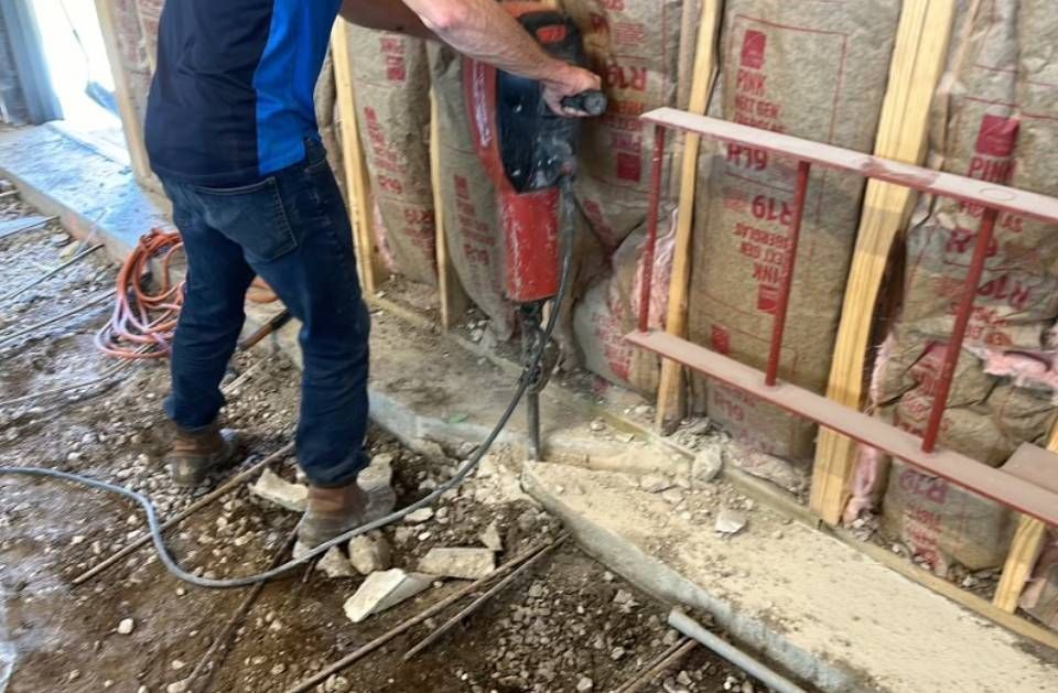 A man is using a hammer to break a wall.