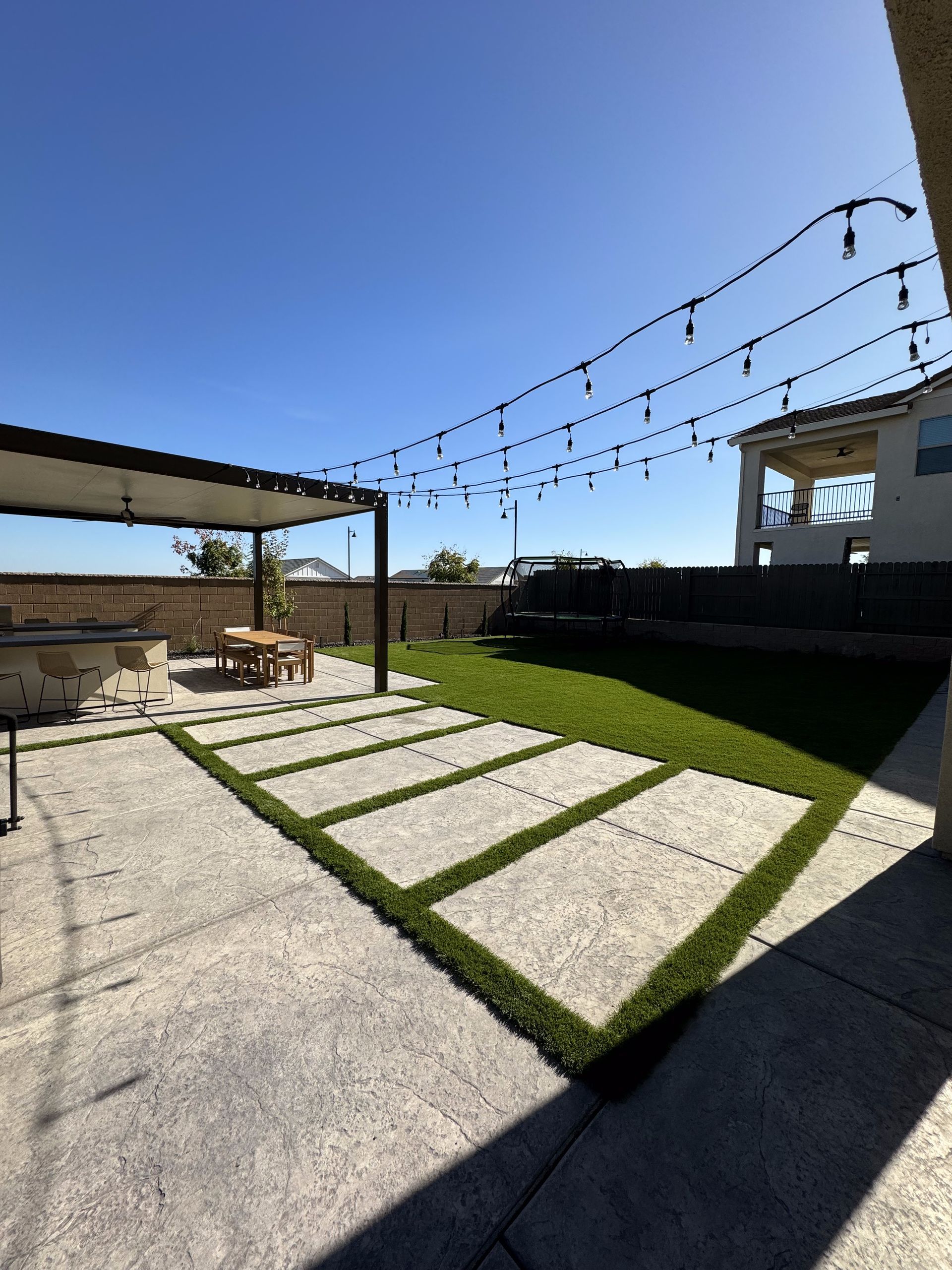 A patio with a table and chairs under a pergola
