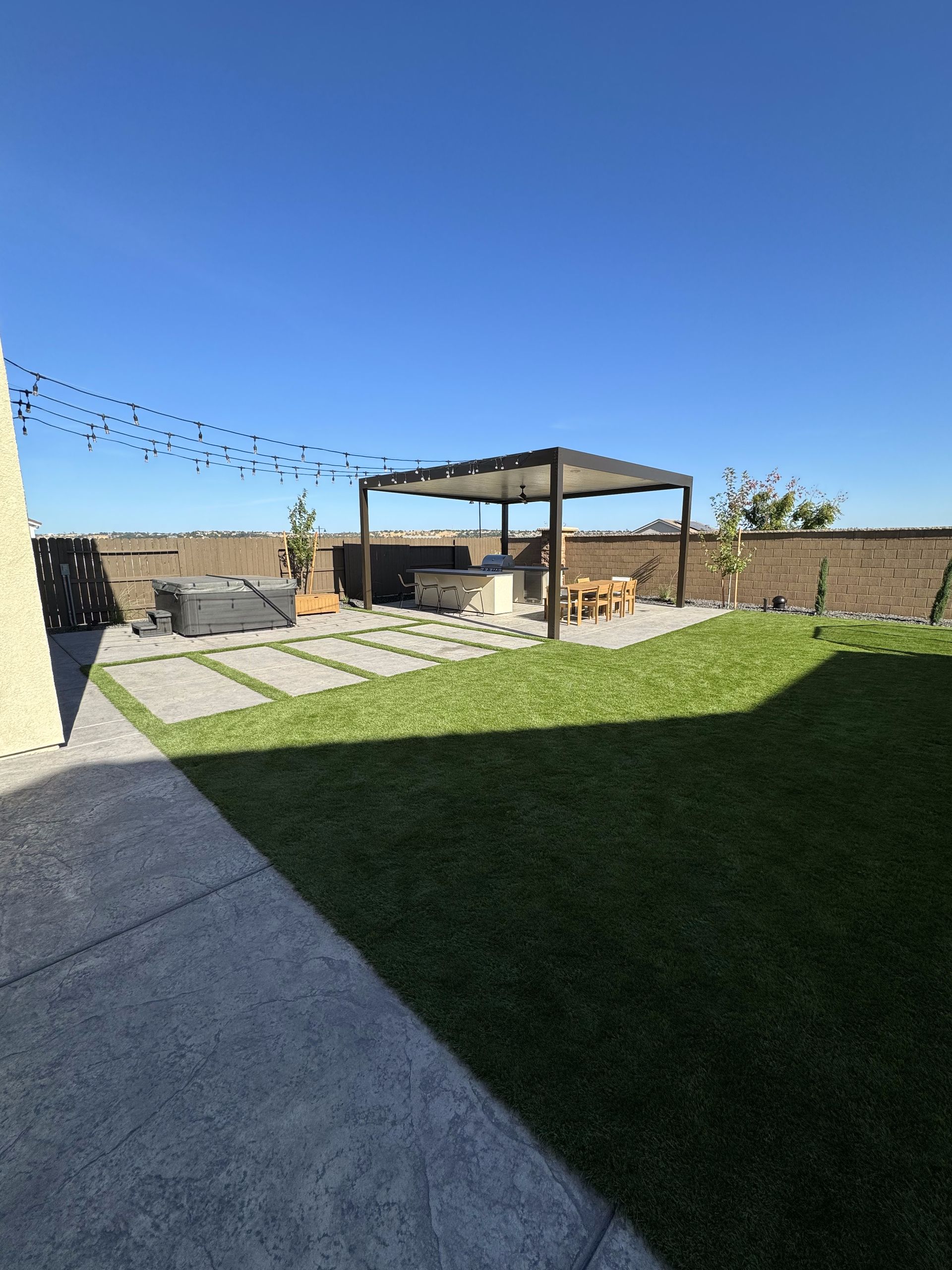 There is a pergola in the backyard of a house.