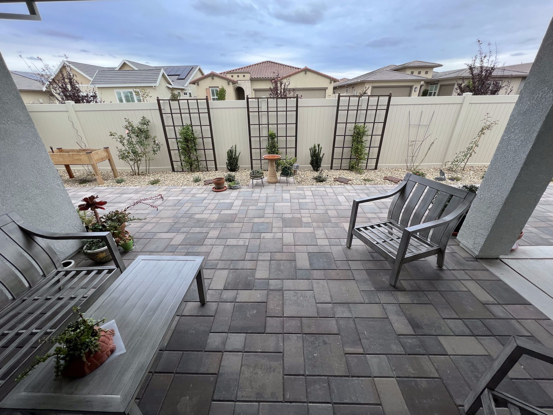 A patio with a bench and chairs and a table