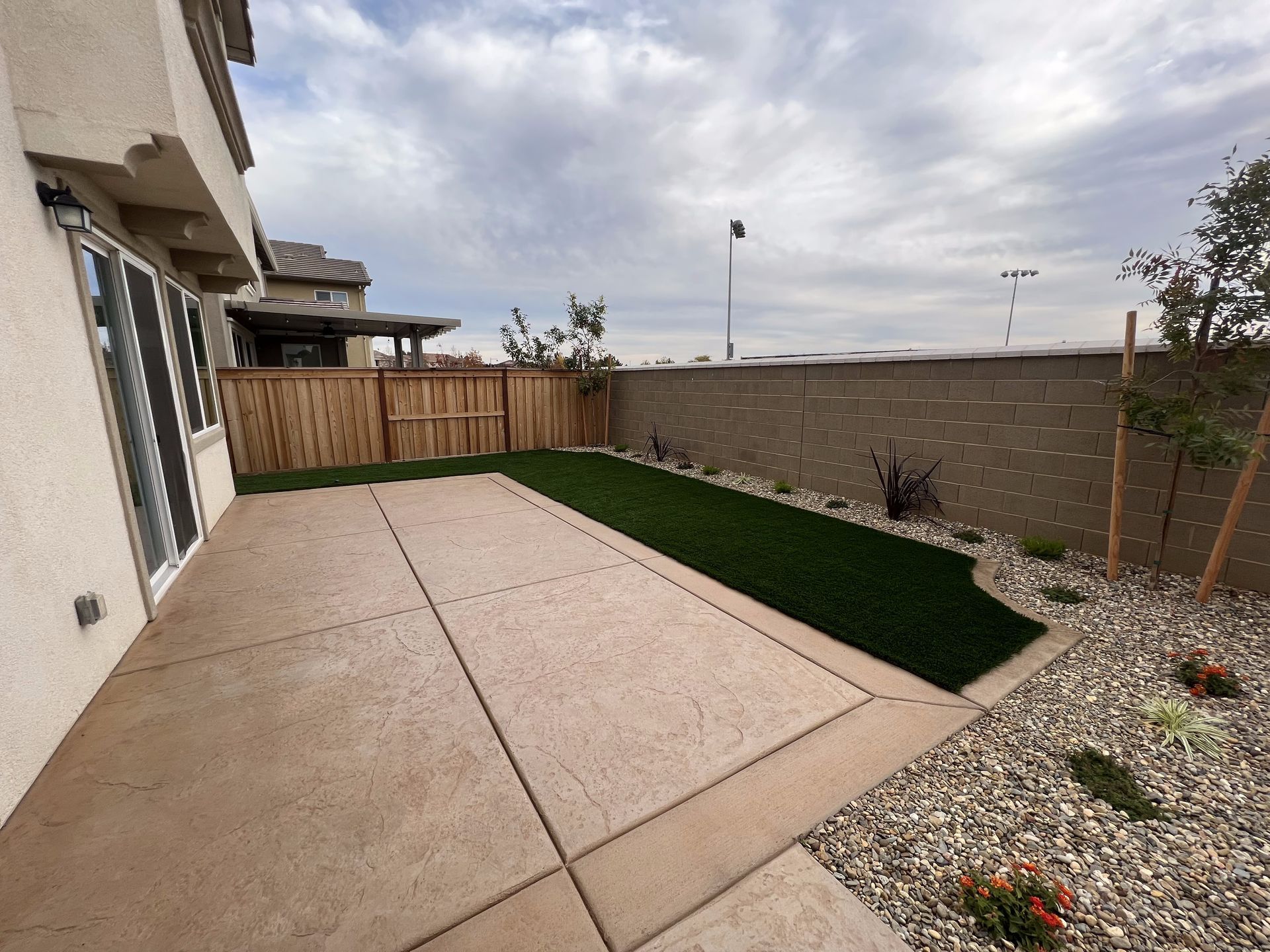 The backyard of a house with a fence and a patio