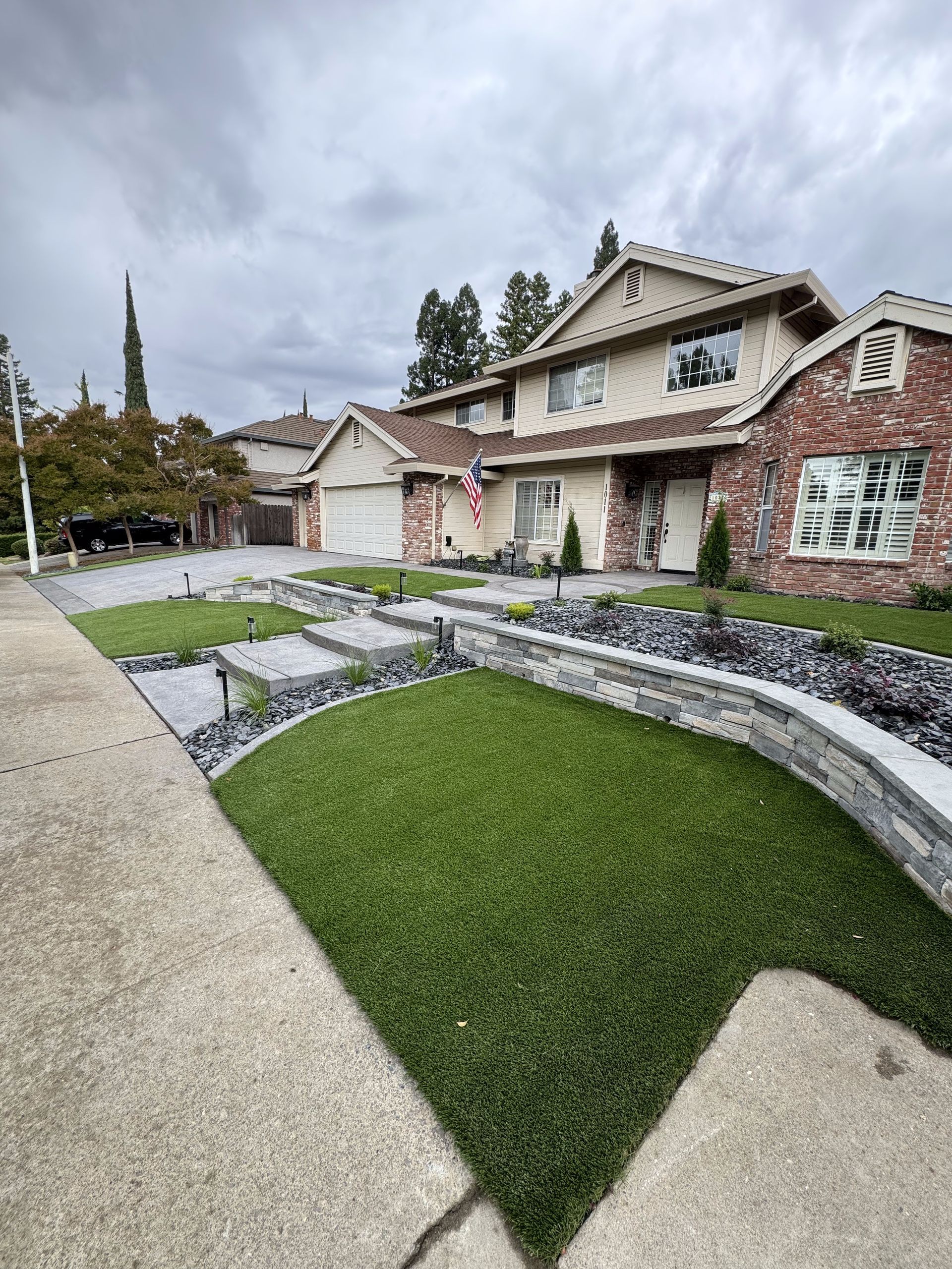 A large brick house with a lush green lawn in front of it.