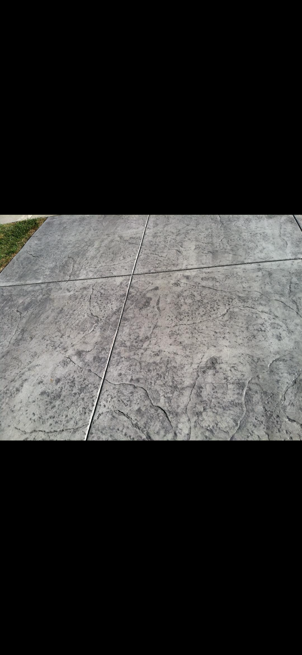 A close up of a concrete driveway with a black background.
