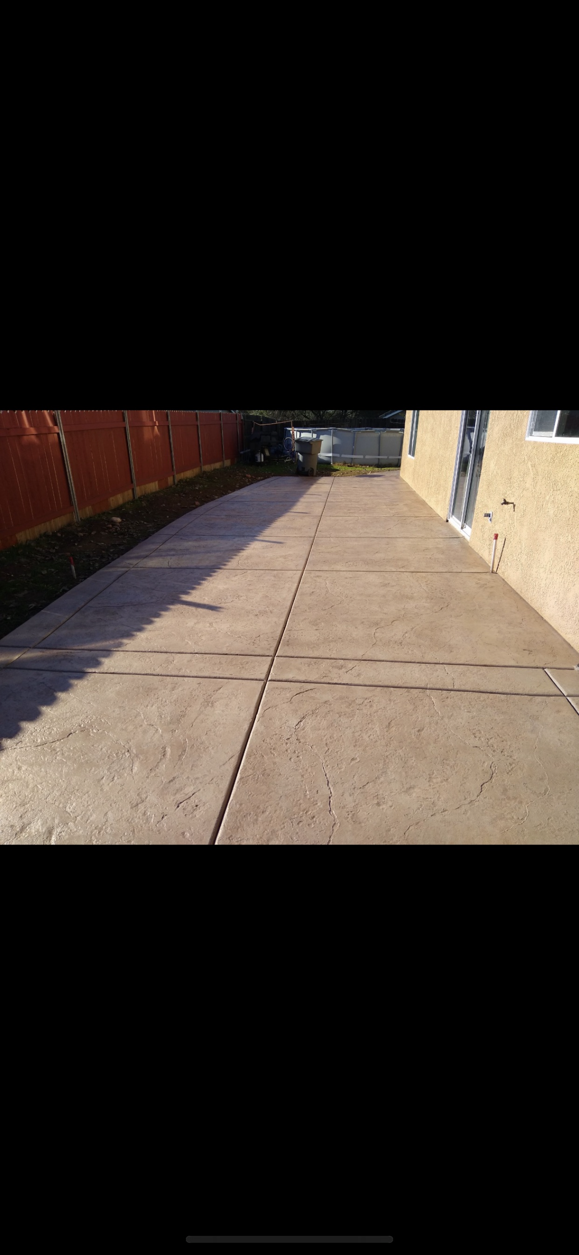 A person is walking down a sidewalk next to a building.