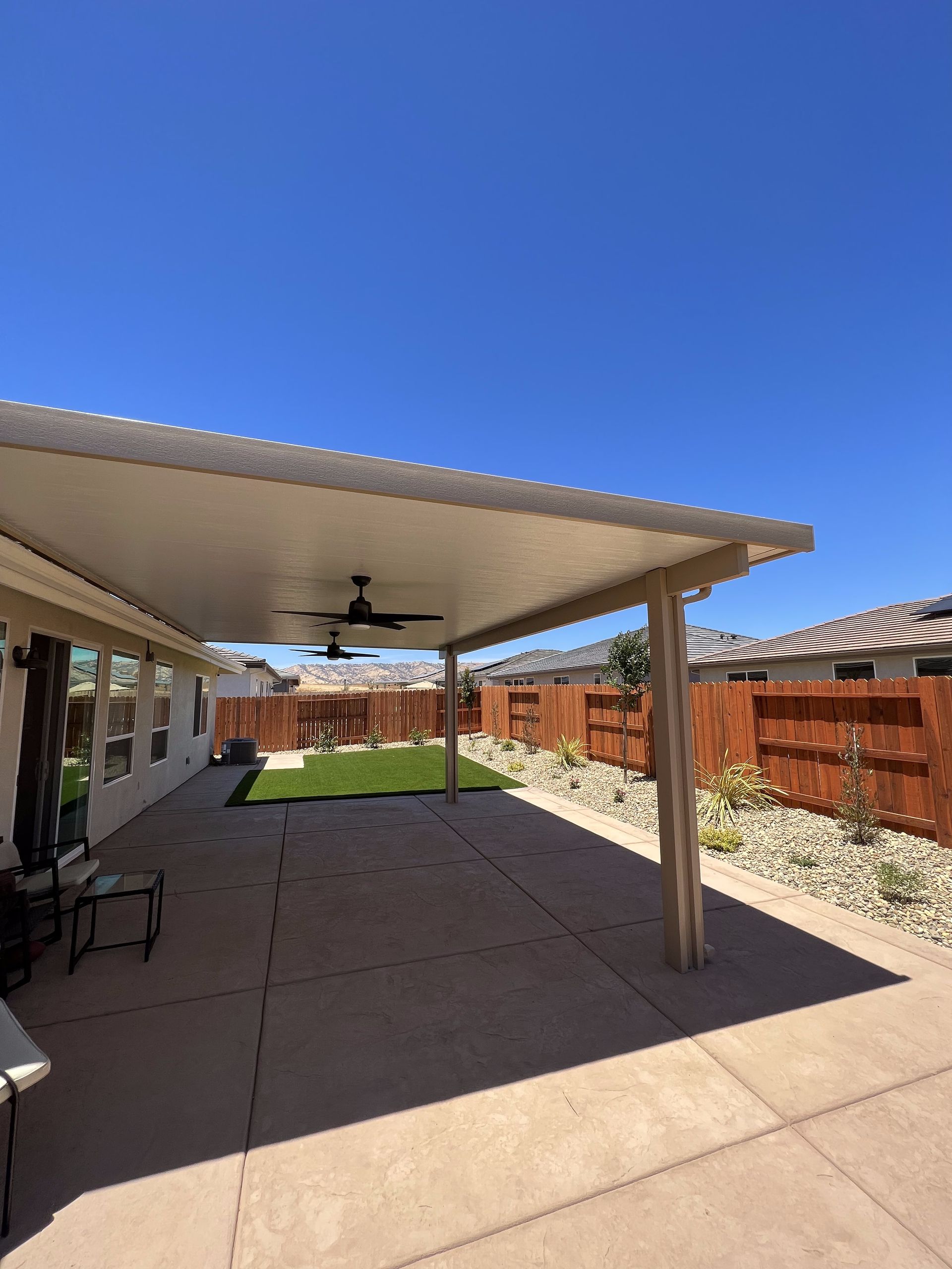 A patio with a ceiling fan on a sunny day