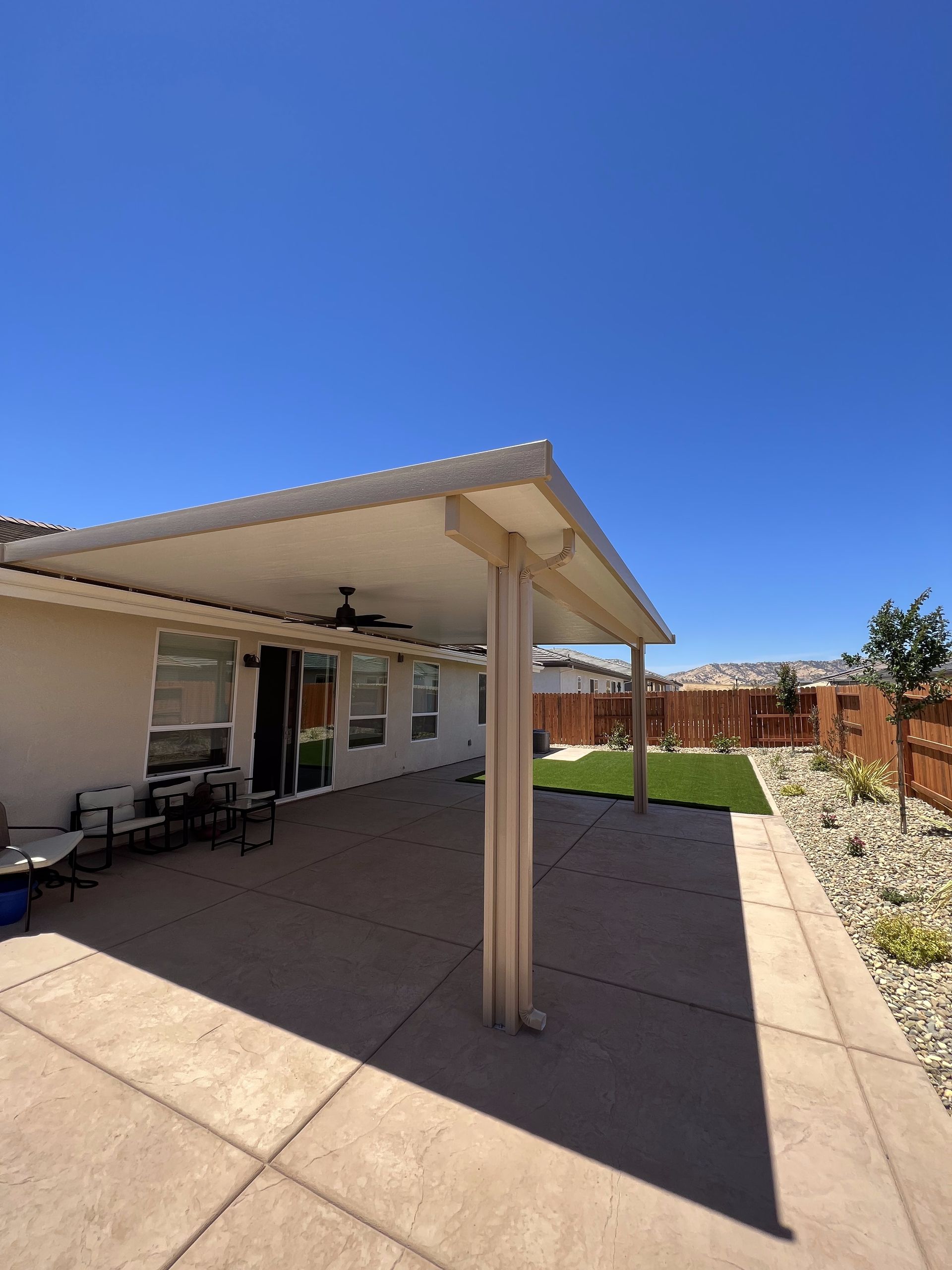 A white house with a covered patio in front of it