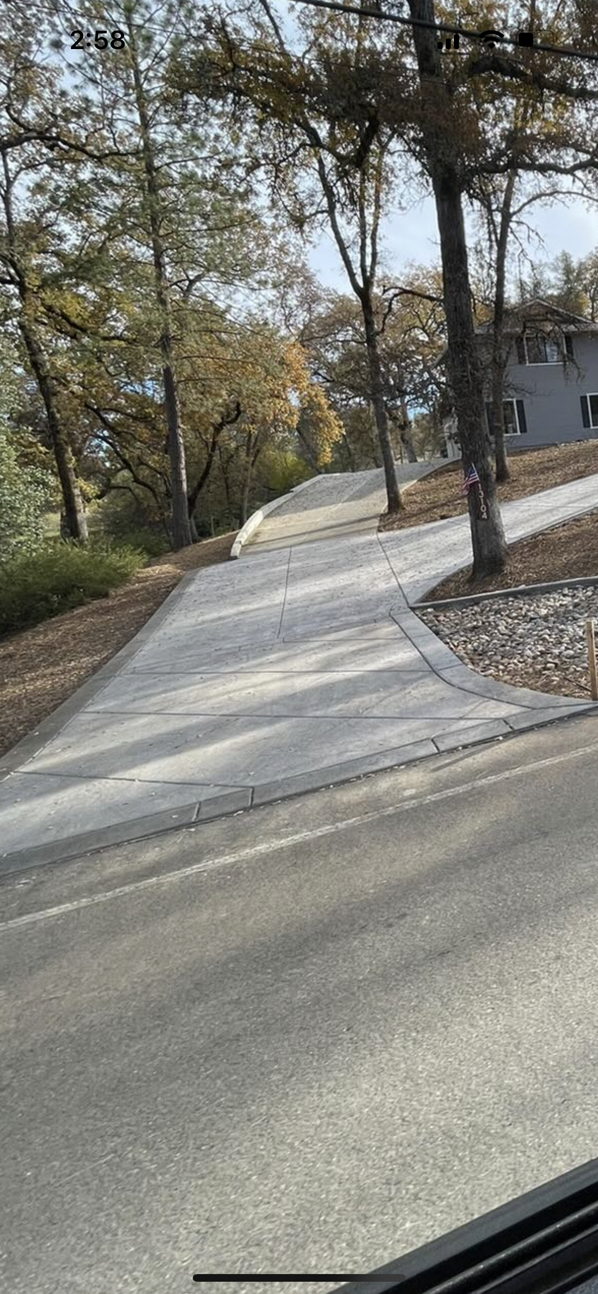 A person is walking down a sidewalk next to a road.