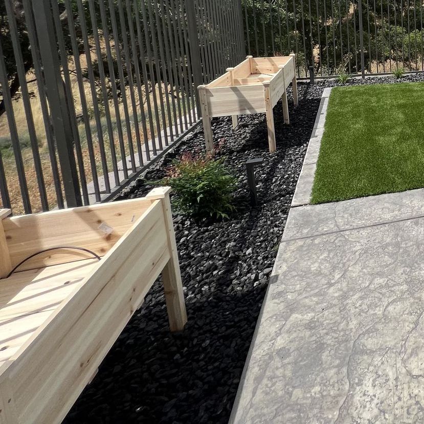 Two wooden planters are sitting next to each other in a garden