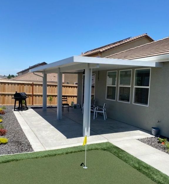 A backyard with a putting green and a wooden fence at night.