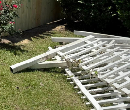 A white picket fence is laying on the grass.