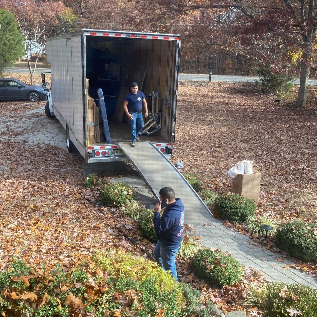 A man is standing in front of a moving truck.