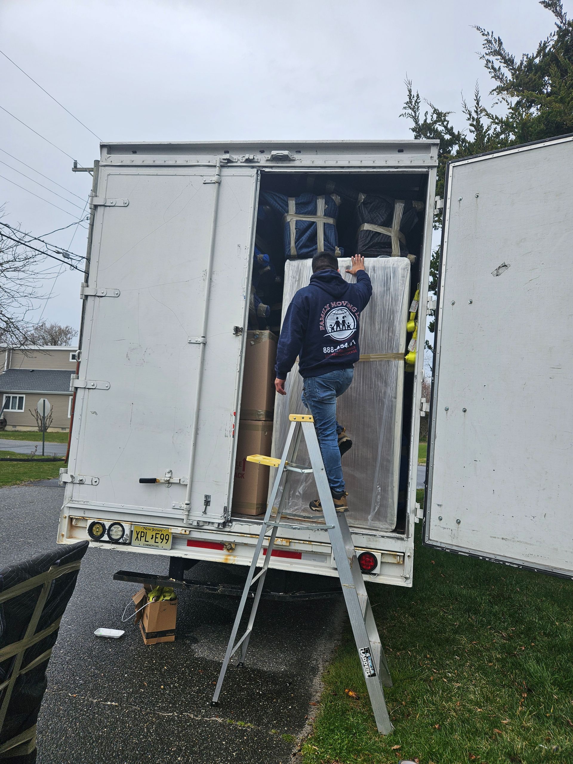 A man is standing on a ladder next to a truck.