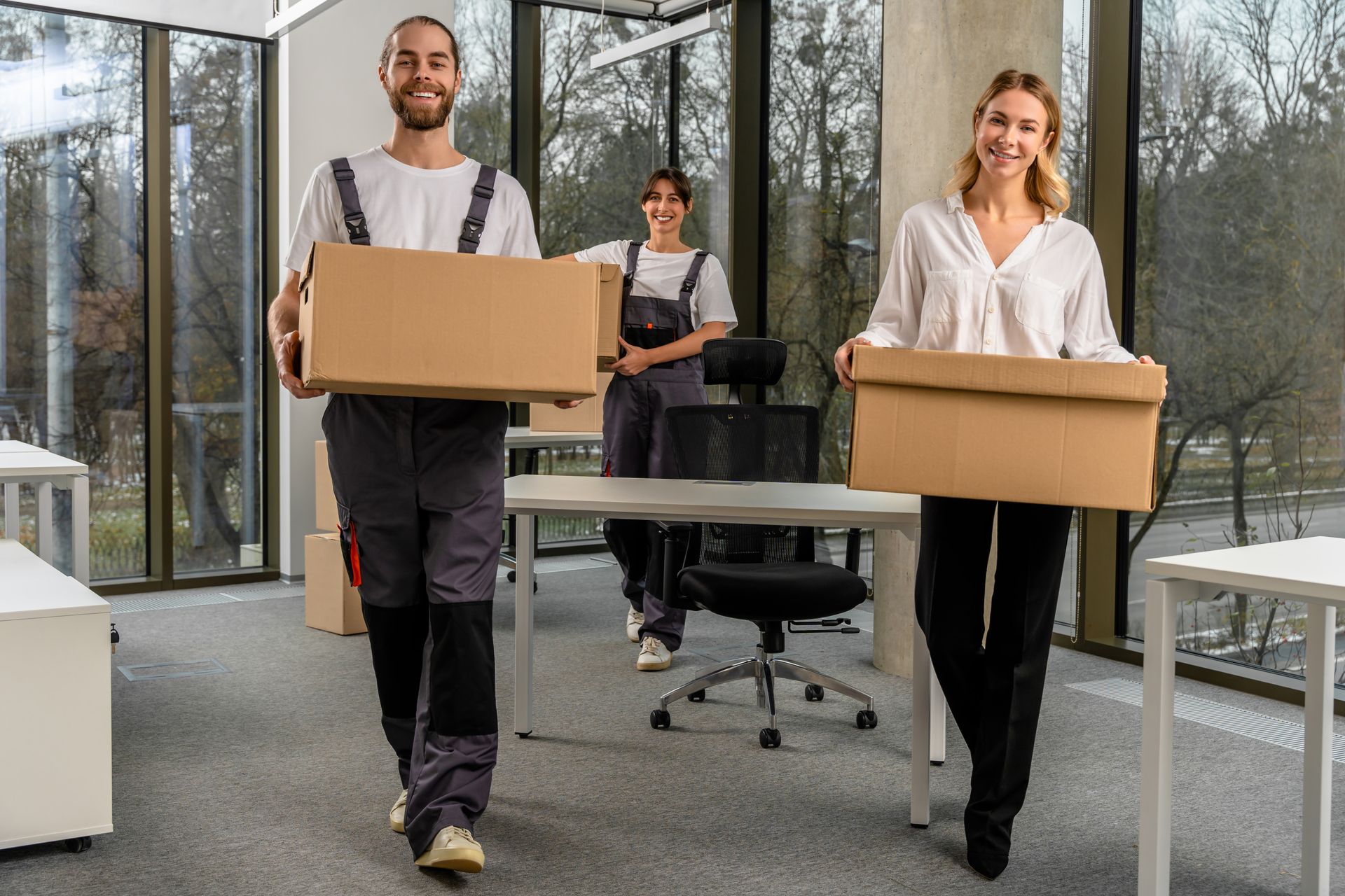 A group of people are carrying boxes into an office.