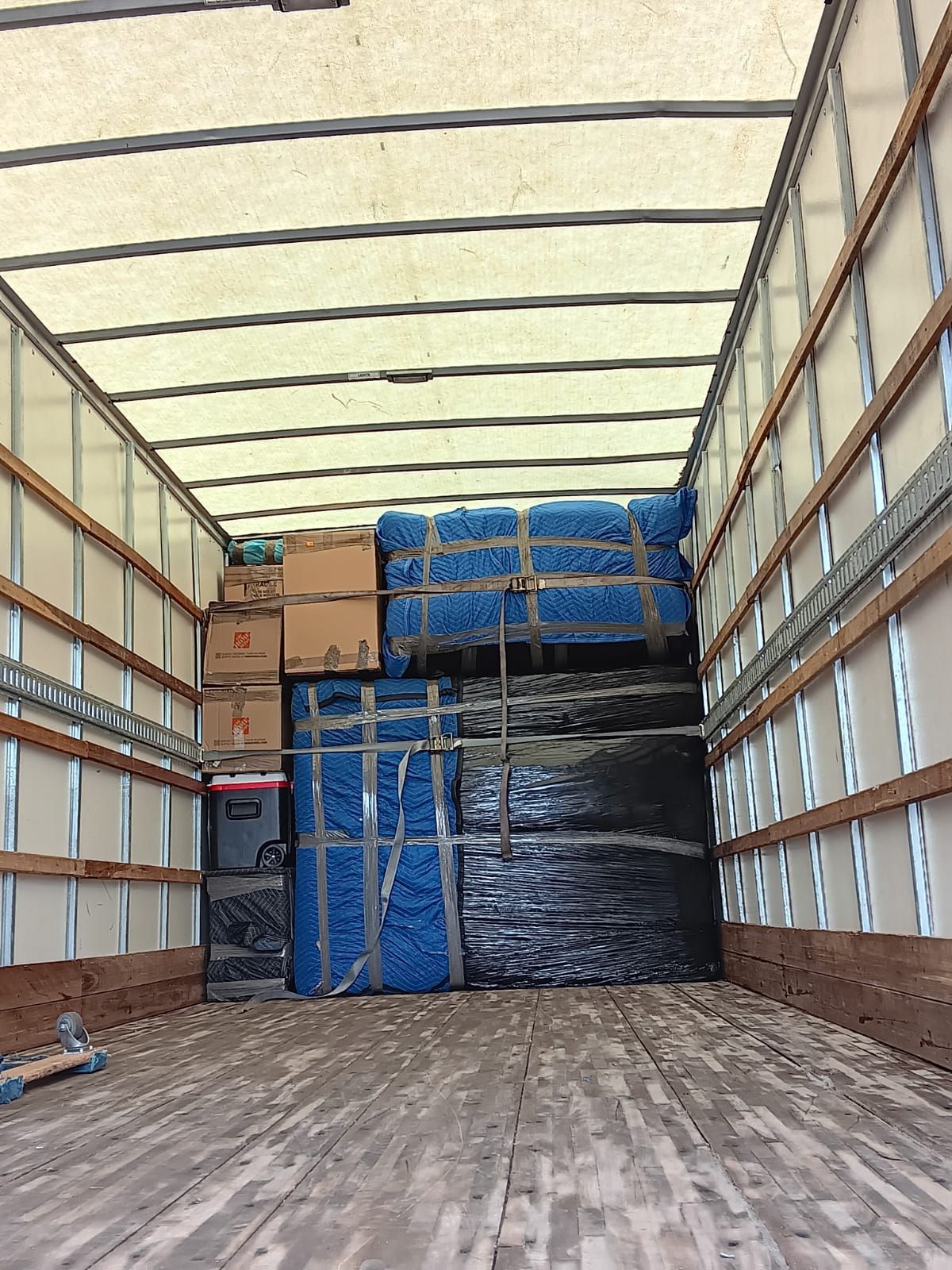The inside of a moving truck filled with boxes and moving supplies.
