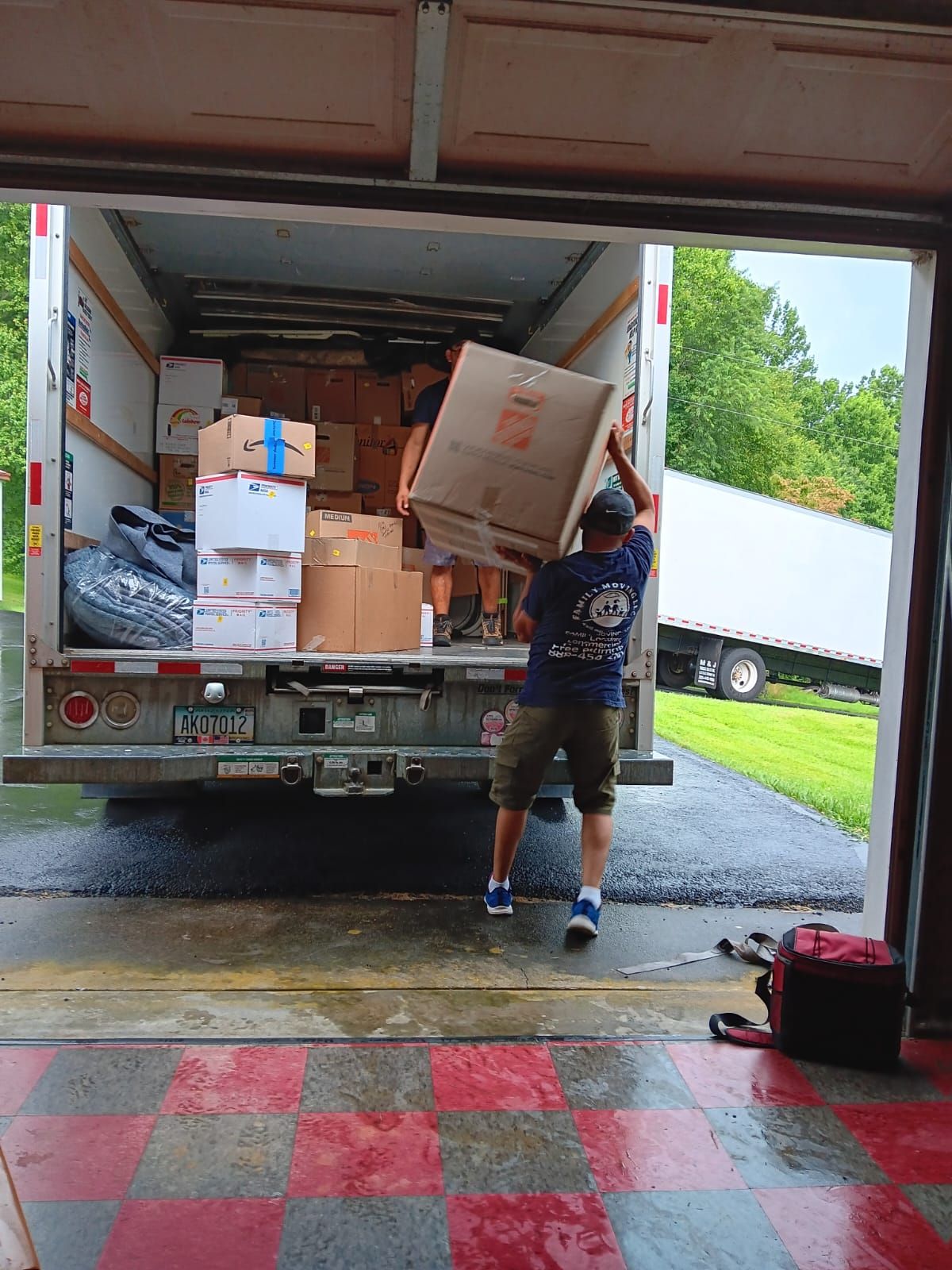 A man is loading boxes into a truck in a garage.