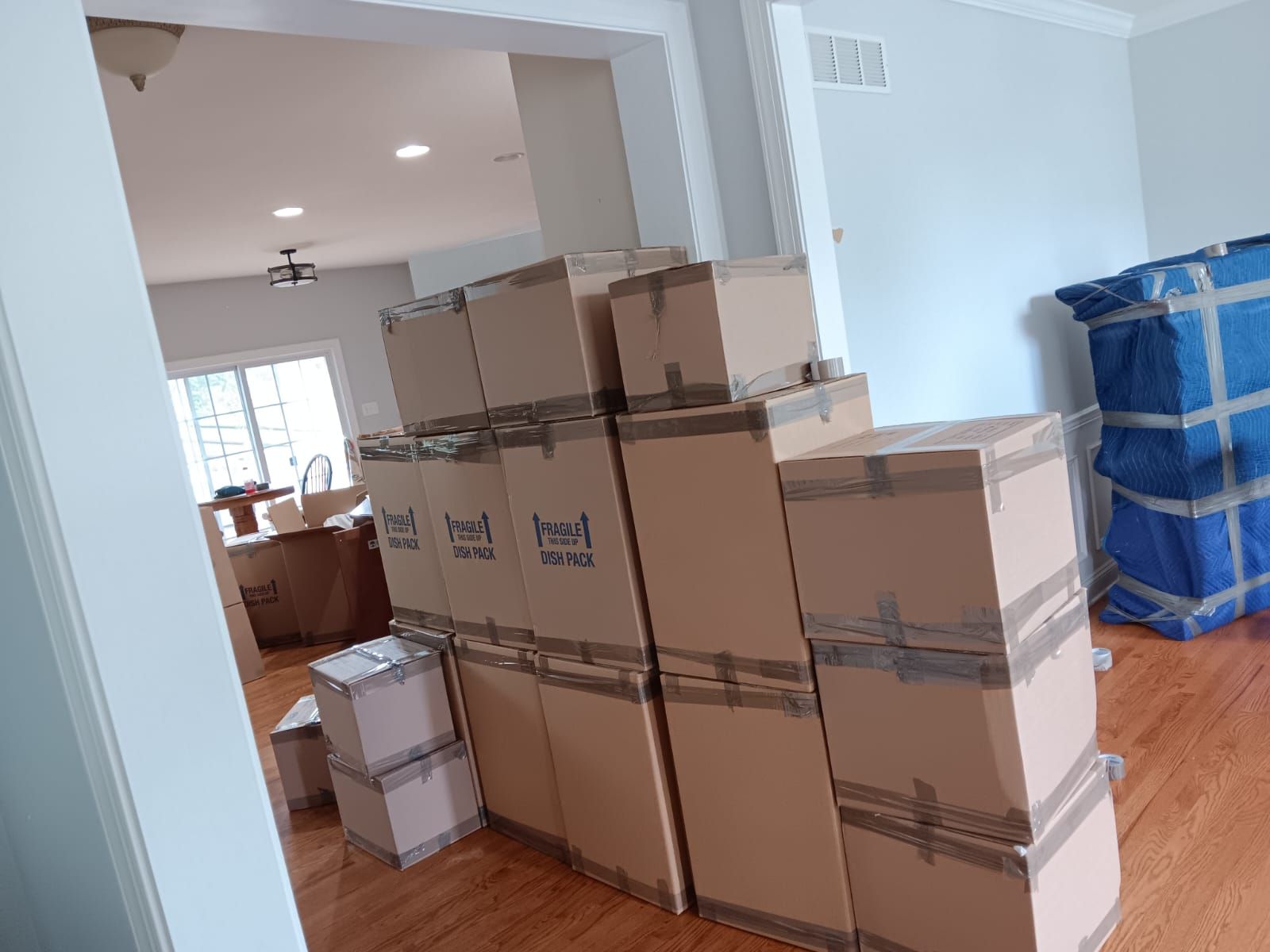 A bunch of cardboard boxes are stacked on top of each other in a living room.