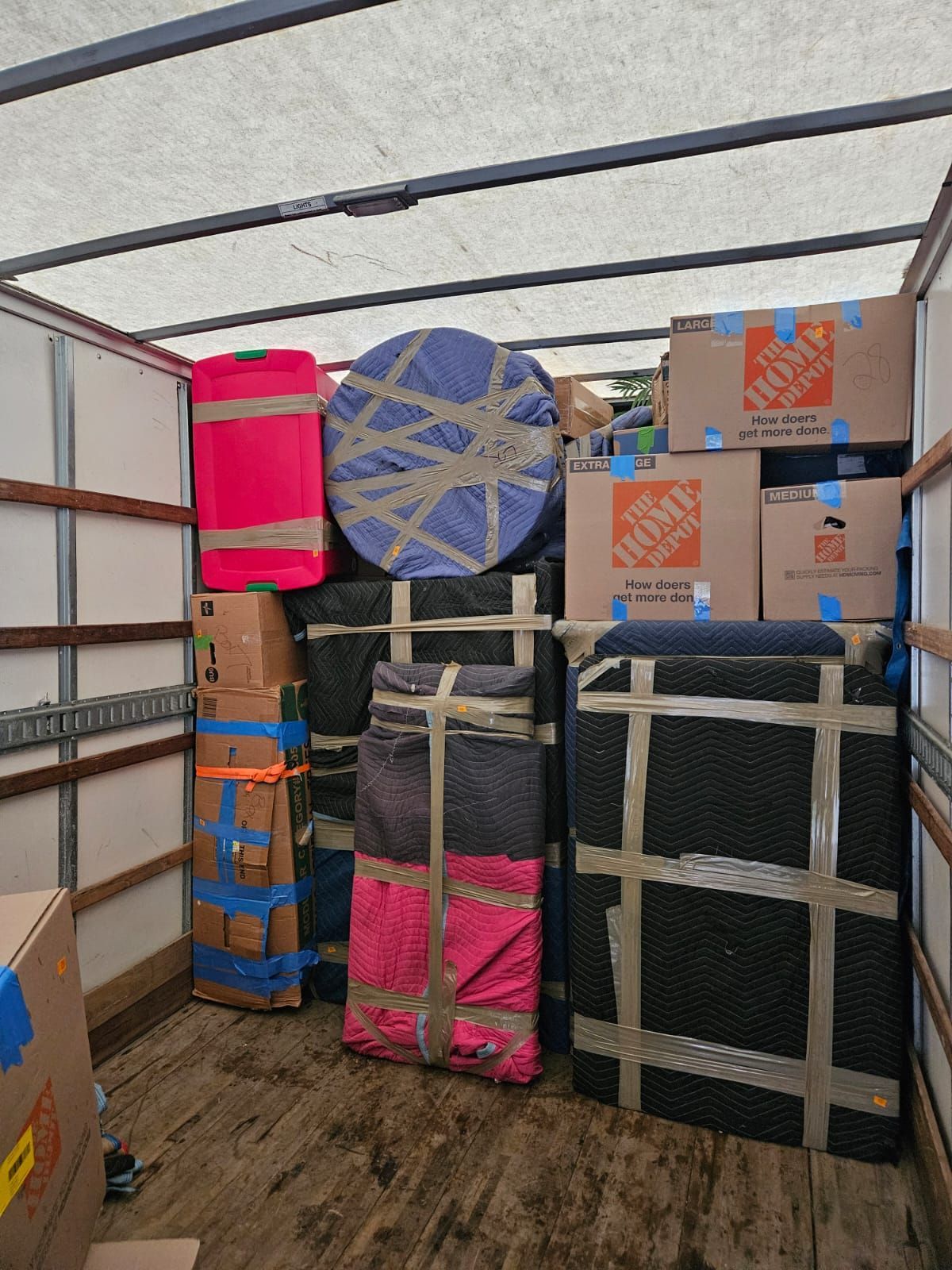 The inside of a moving truck filled with boxes and furniture.