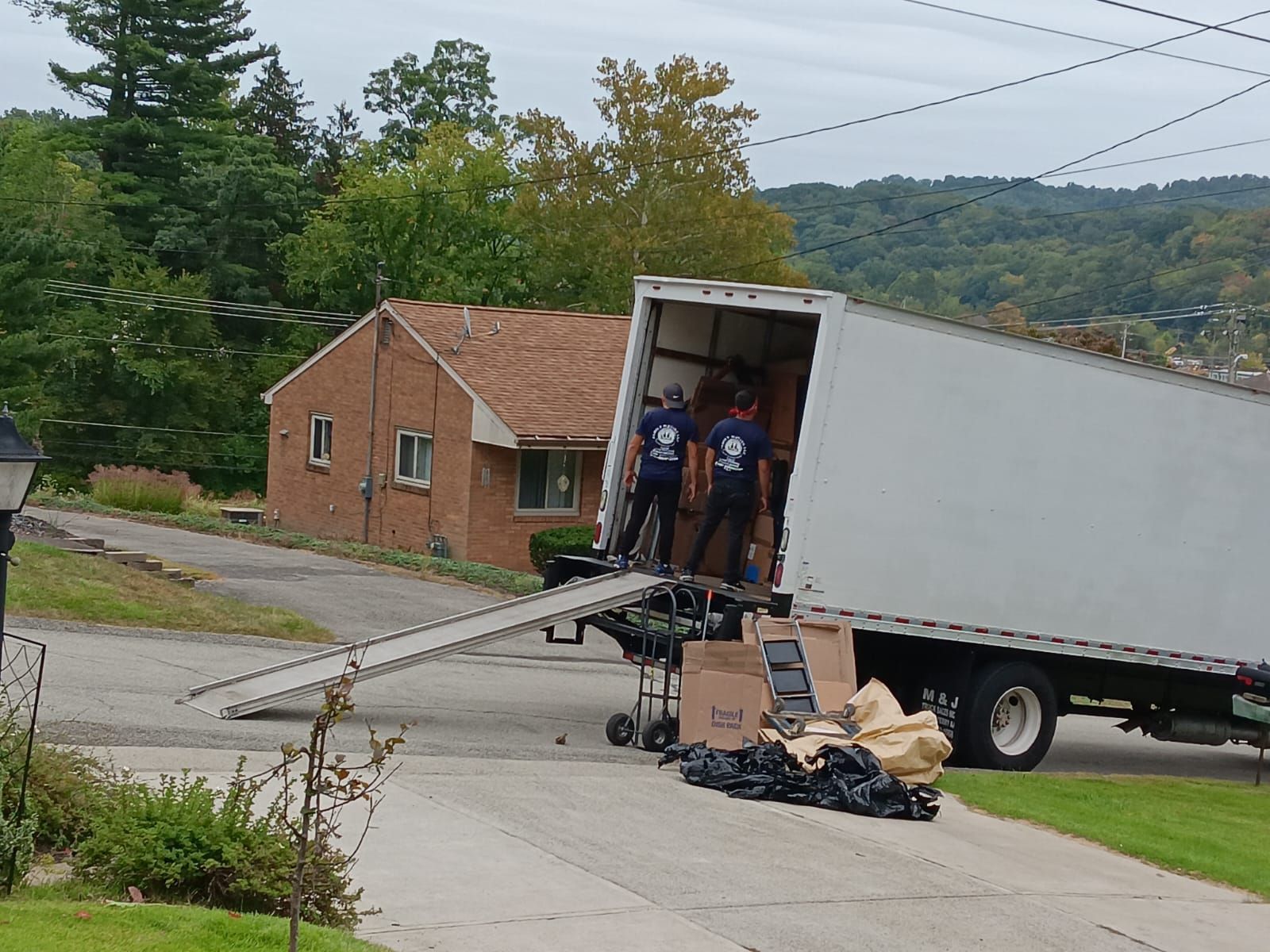 A moving truck is parked in front of a brick house