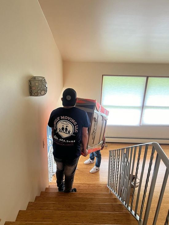 A man is carrying a box up a set of stairs.