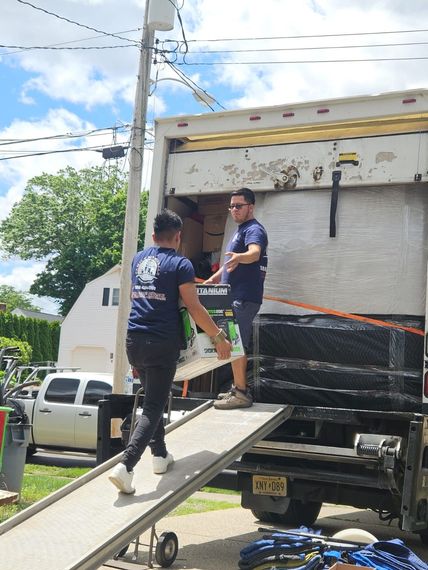 Two men are loading boxes into a moving truck.