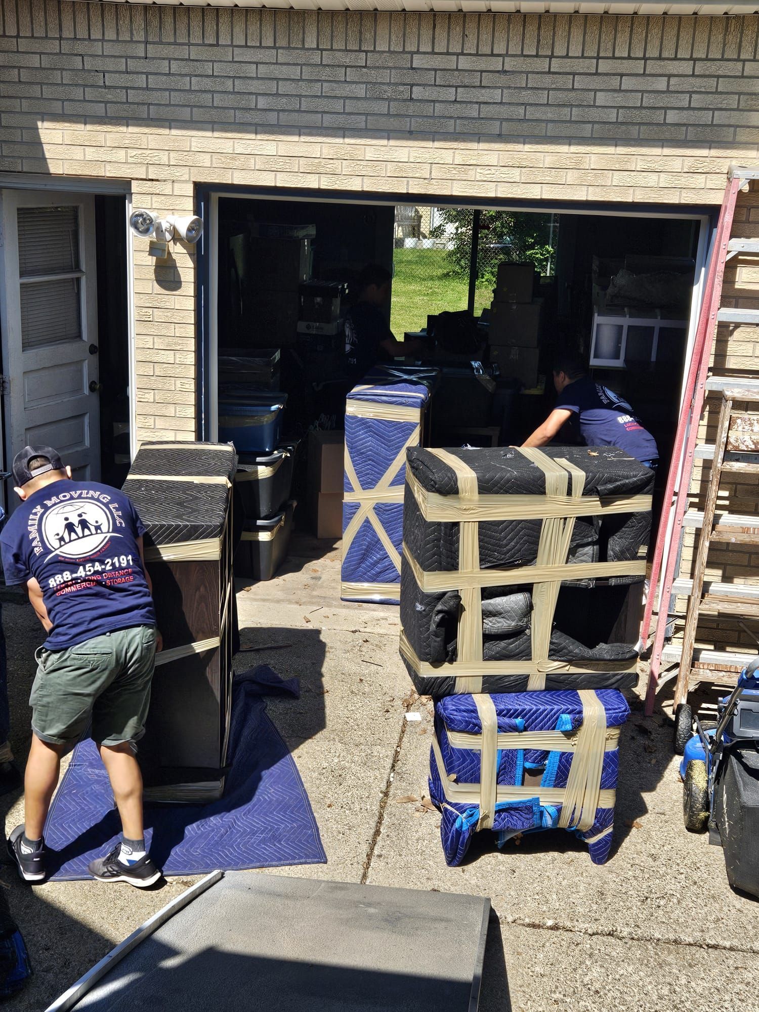 A group of men are moving a piano into a garage.