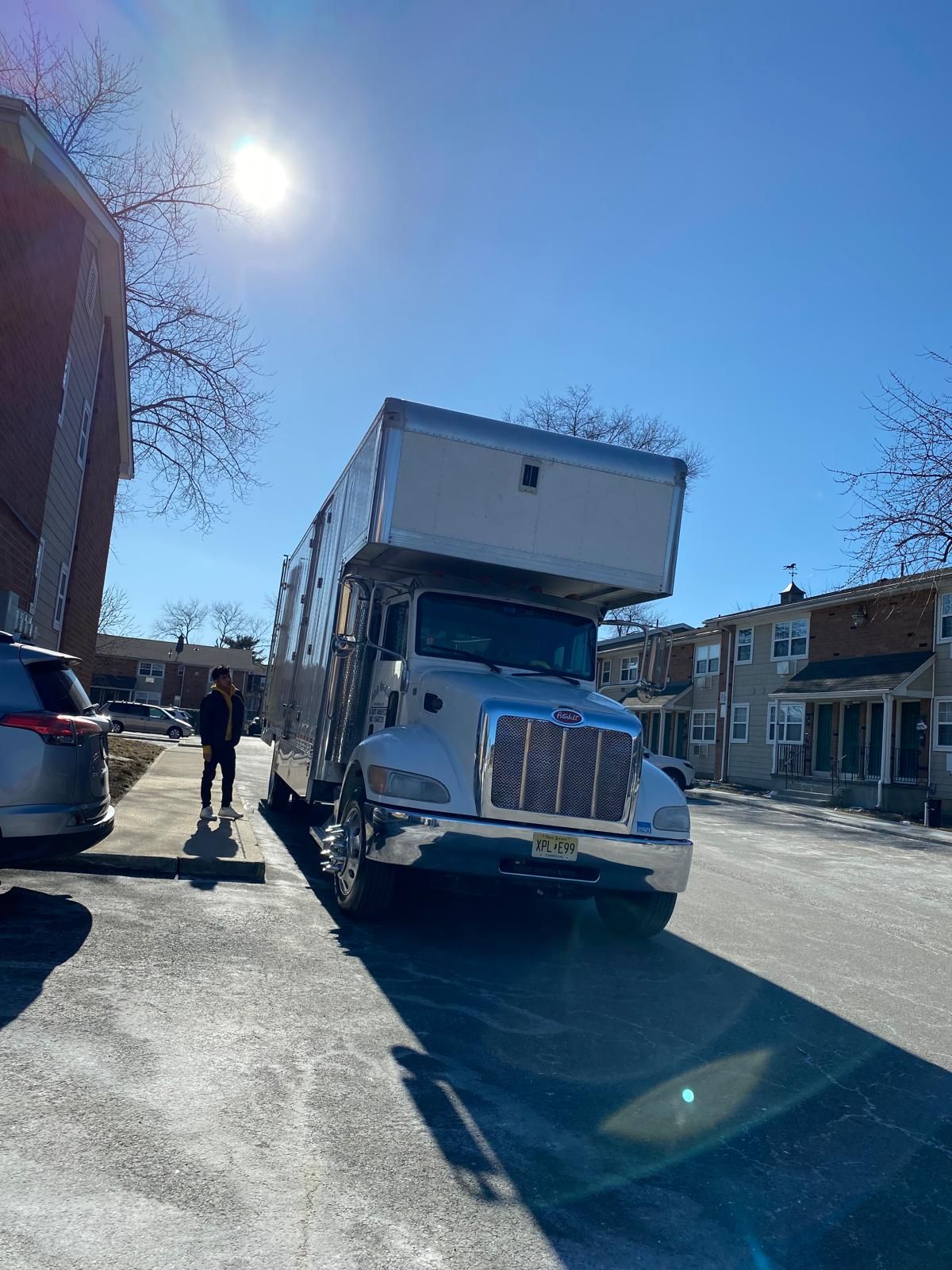 A large moving truck is parked on the side of the road.