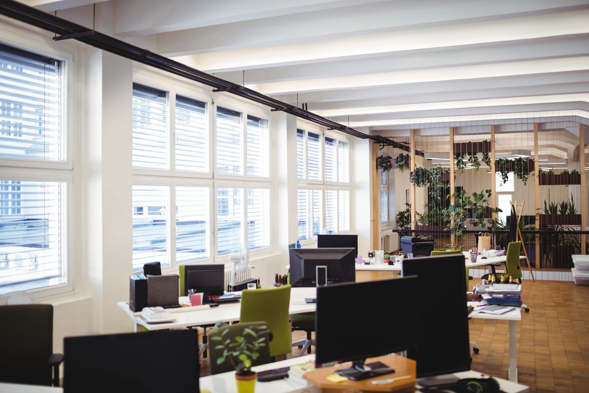 A large empty office with lots of windows and desks.