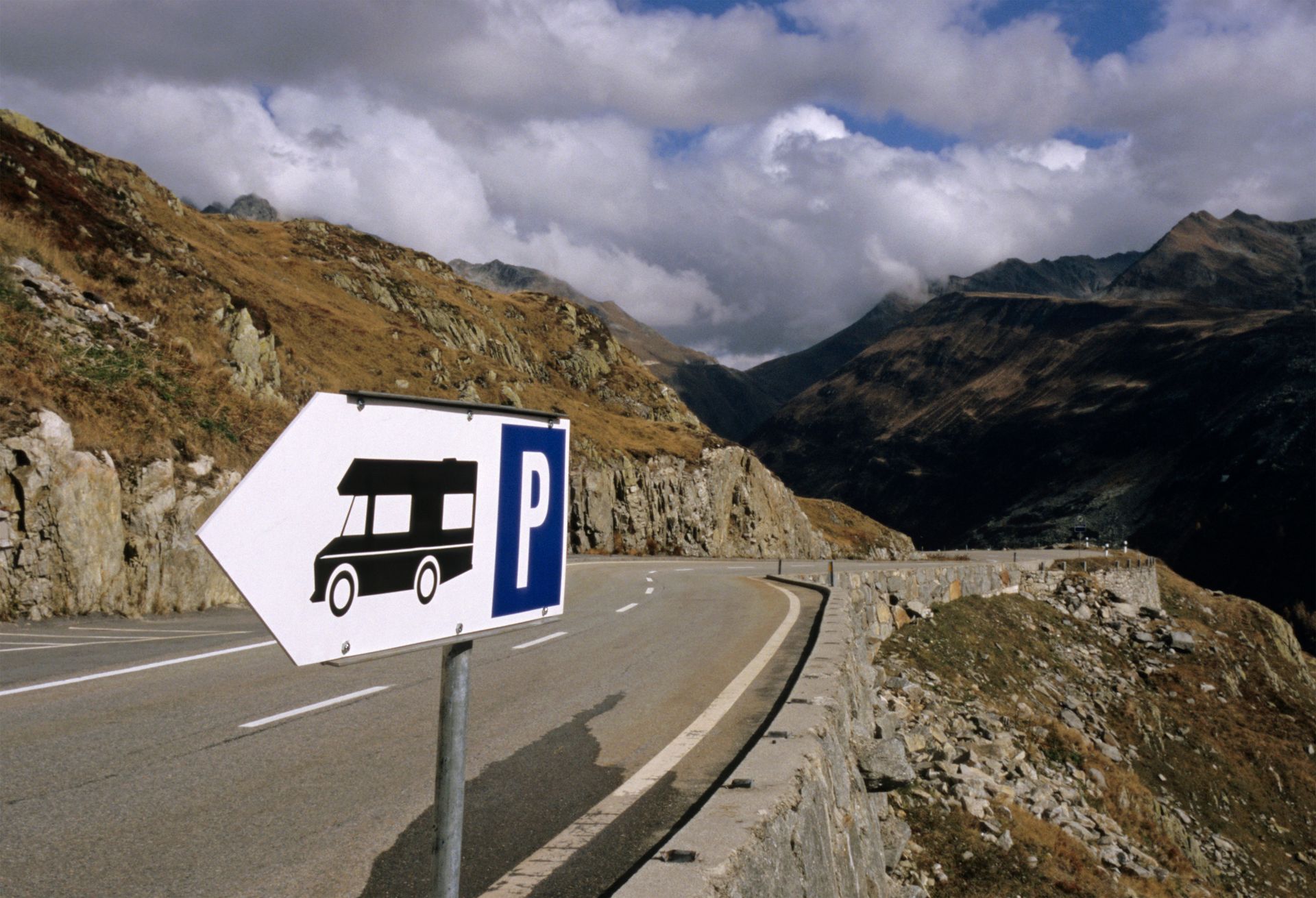 A sign on the side of a road points to a parking spot