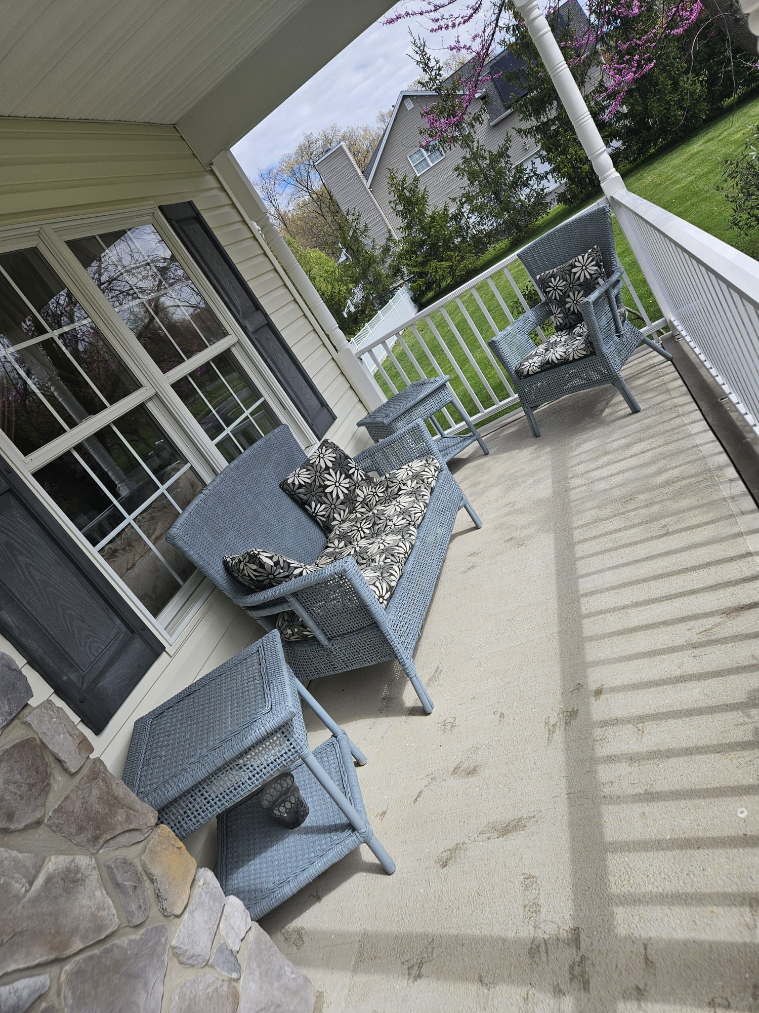 A porch with wicker furniture and a white railing