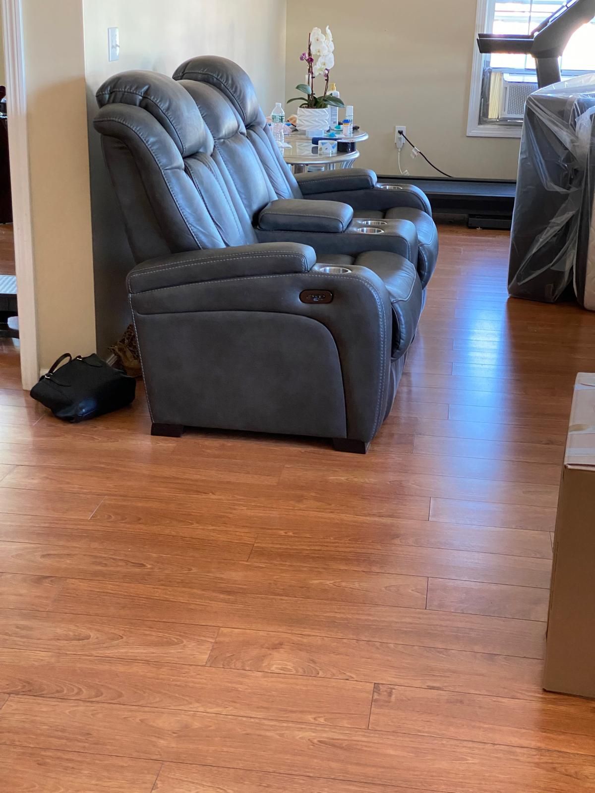 A living room with a couch and two chairs on a wooden floor.