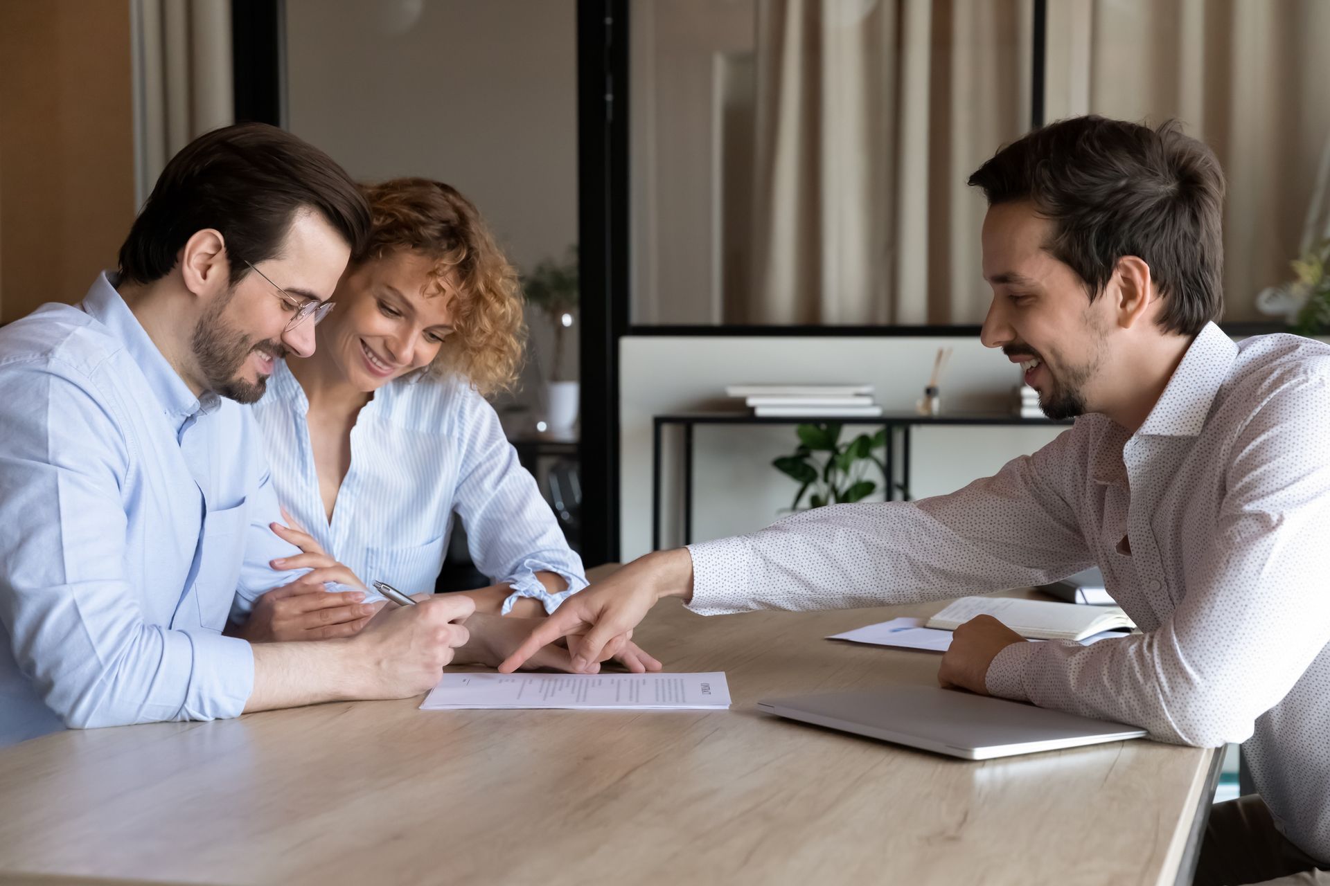 A man and a woman are sitting at a table signing a document.