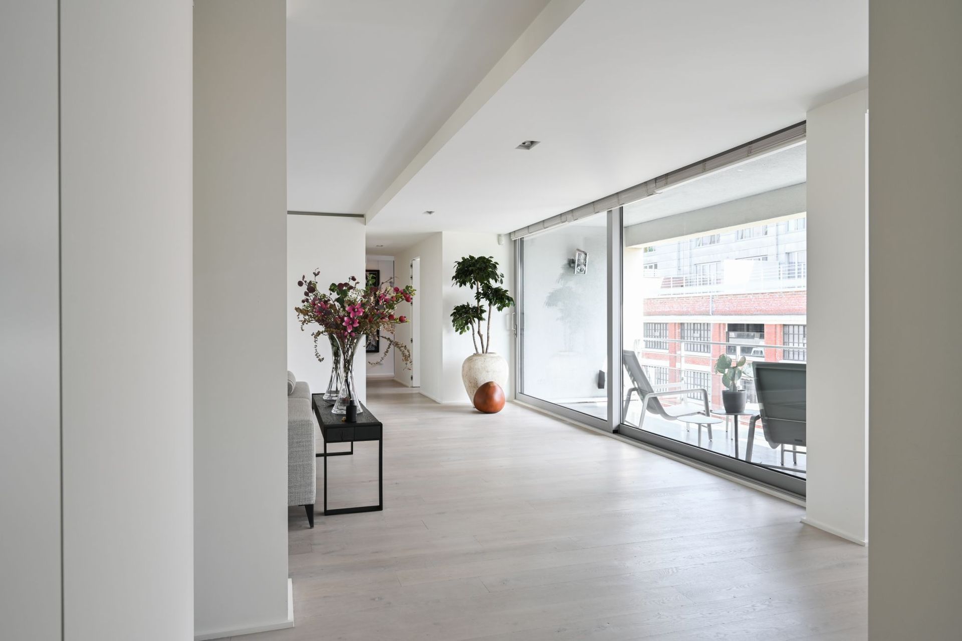 Er staat een tafel met bloemen in het midden van de kamer.