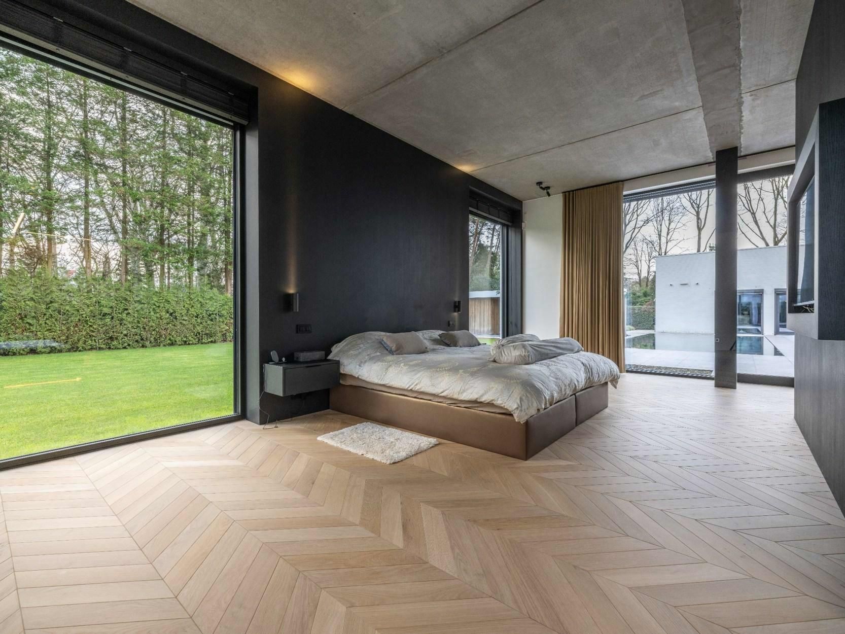 Een slaapkamer met een groot bed en een groot raam.